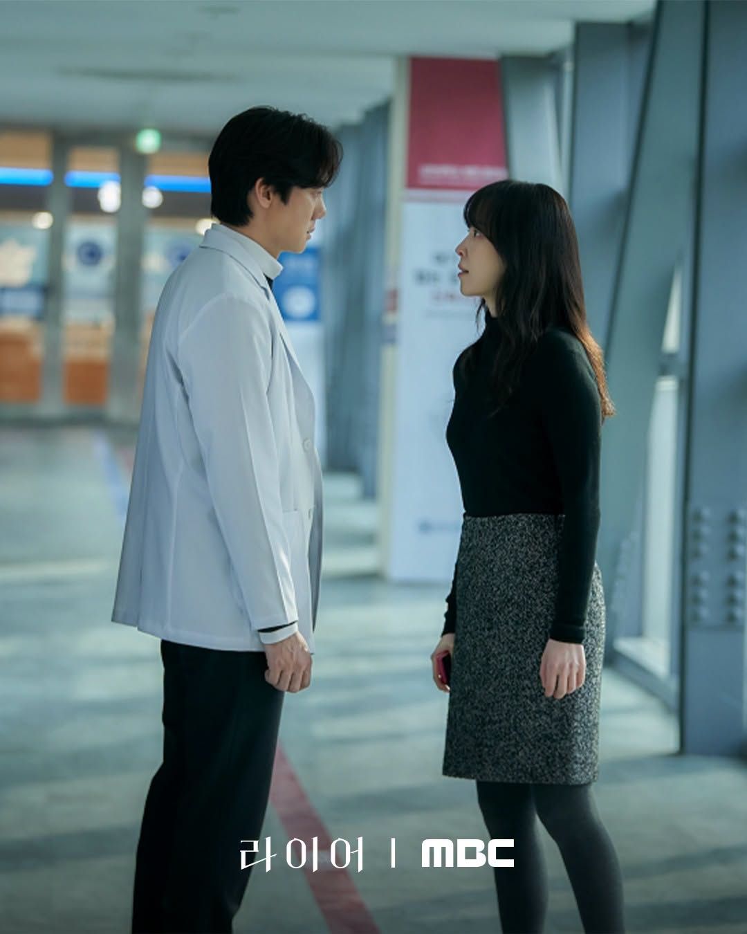 Yoo Yeon-seok and Seo Hyun-jin facing each other in a corridor in Liar