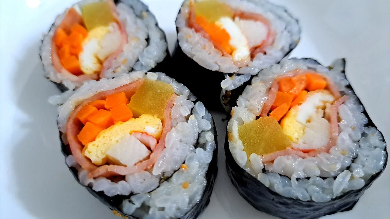 Sliced gimbap showing rice, seaweed and colorful fillings; illustrative food photograph, not a reviewed restaurant meal.